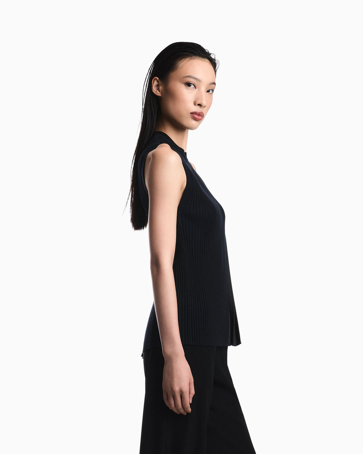 Knit top with asymmetrical and sleeveless ribbed design and pleated panel