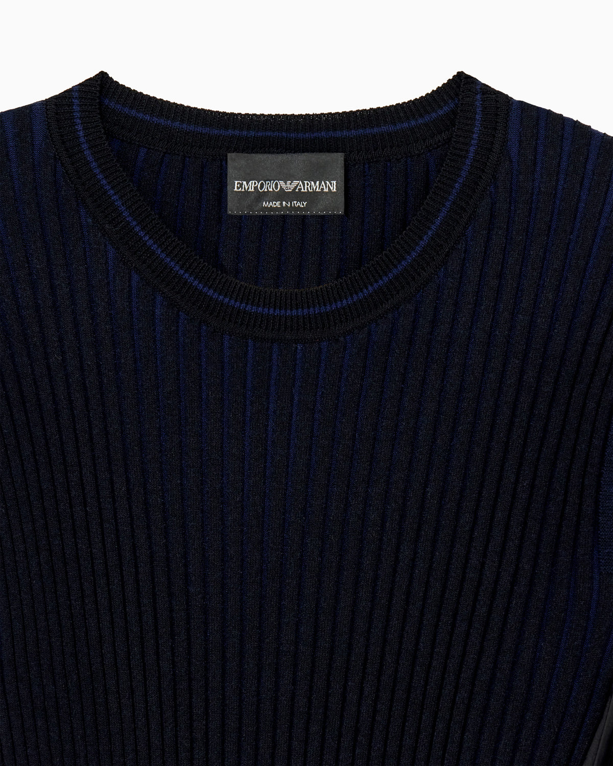 Knit top with asymmetrical and sleeveless ribbed design and pleated panel