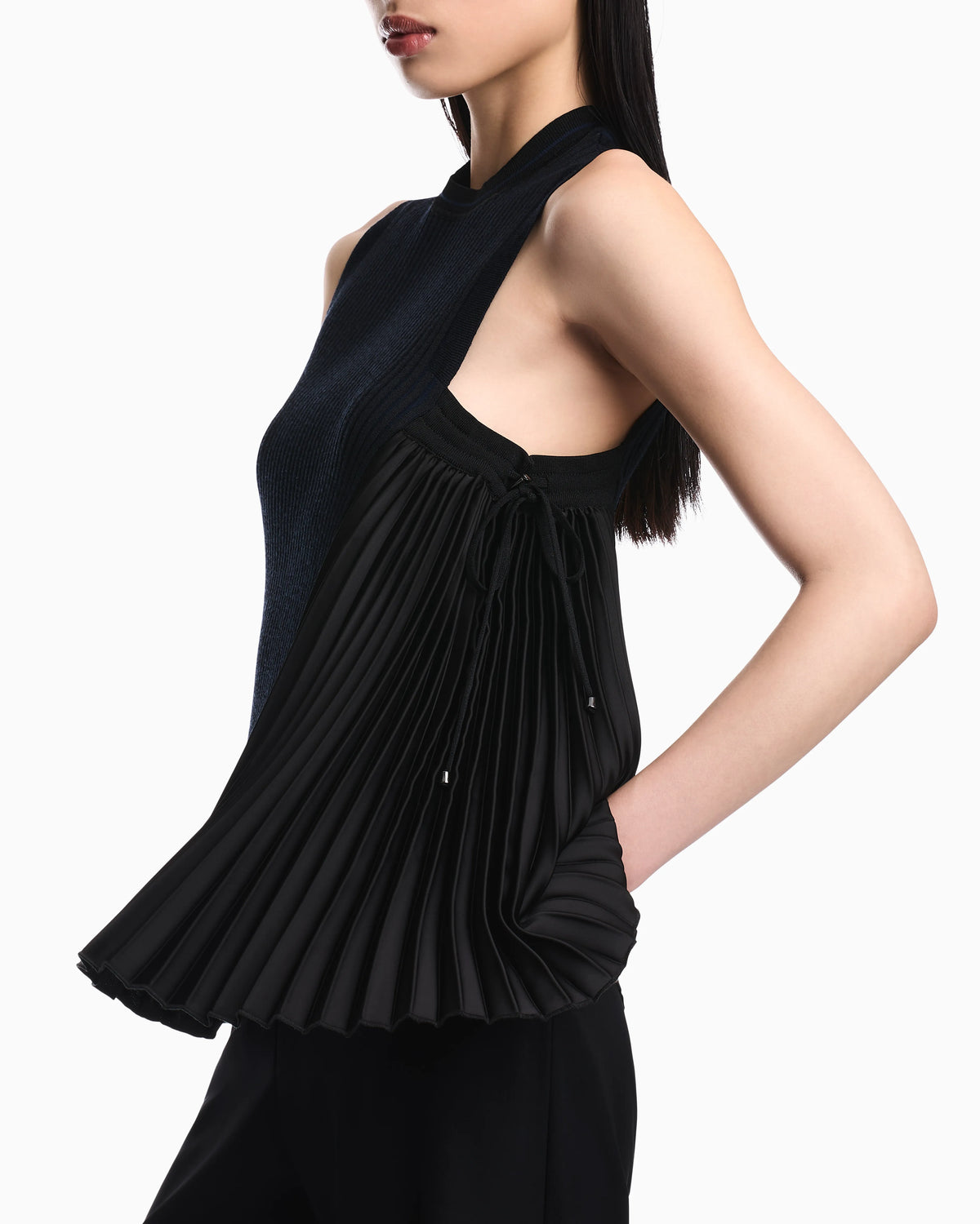 Knit top with asymmetrical and sleeveless ribbed design and pleated panel